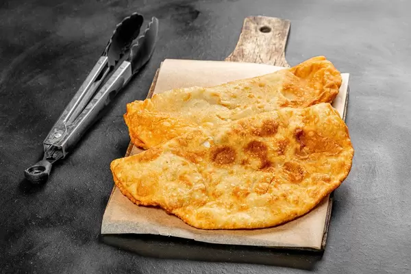 Fried fresh chebureks on a black background (Flip 2019)