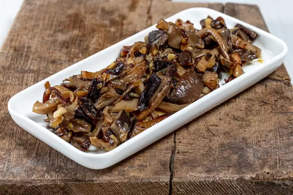 Fried mushrooms with onions on old wooden kitchen Board (Flip 2019)