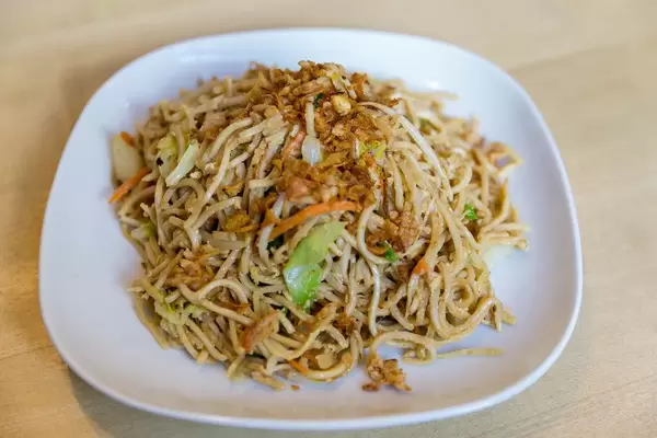 Fried noodles with egg and fresh vegetables as vegetarian lunch at the Asian restaurant