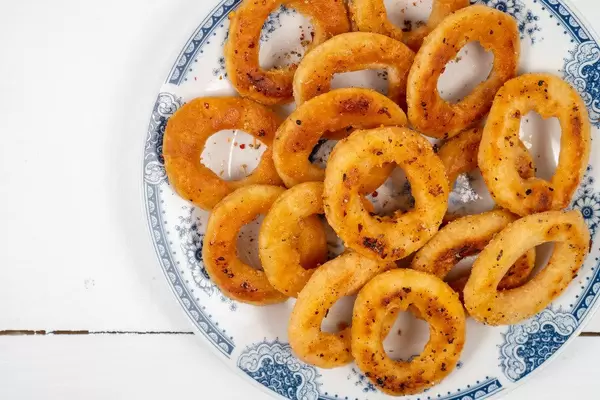 Fried Onion Rings served on the white plate above wooden table