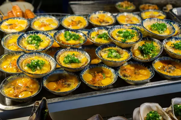 Fried Quail Eggs with Spring Onions and Spices in Small Ceramic Bowls sold at a Street Food Cart on Phu Quoc Island, Vietnam