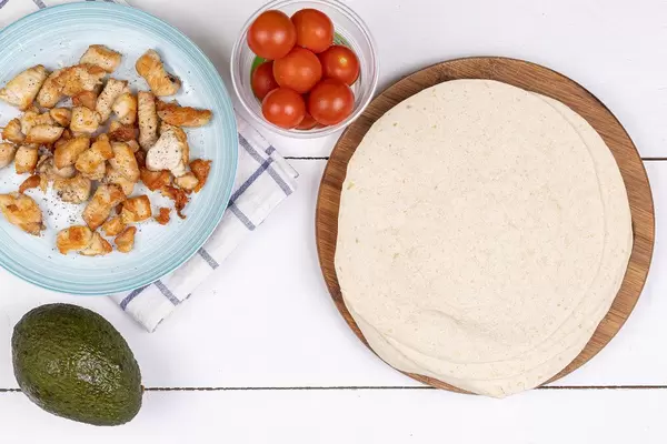 Fried sliced Chicken Breasts with Avocado Cherry Tomato and Tortillas