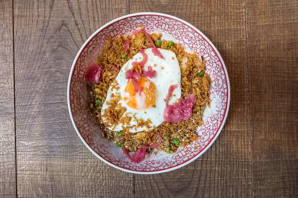 Fried Sunrice in the coa Wok & Bowls restaurant in Cologne: fried rice with peas, carrots, onions, chili, ginger, garlic and fried egg on the top