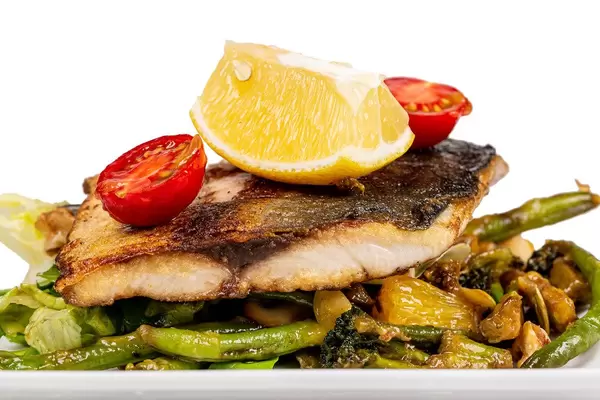 Fried tuna fillet on grilled vegetables with orange sauce