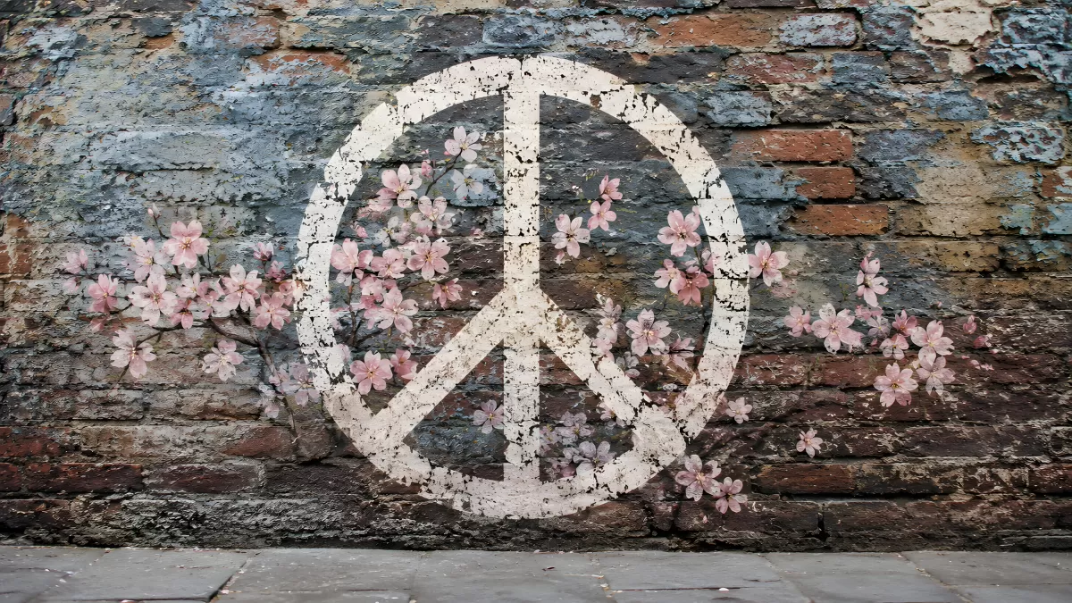 Friedenszeichen mit Kirschblüten auf alter Backsteinwand