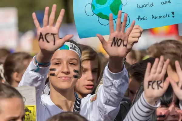 Friedliche Demonstration am Protesttag für eine Klimawende. Schülerin mit Handbemalung fordert von Politikern "Act now" - Handelt jetzt