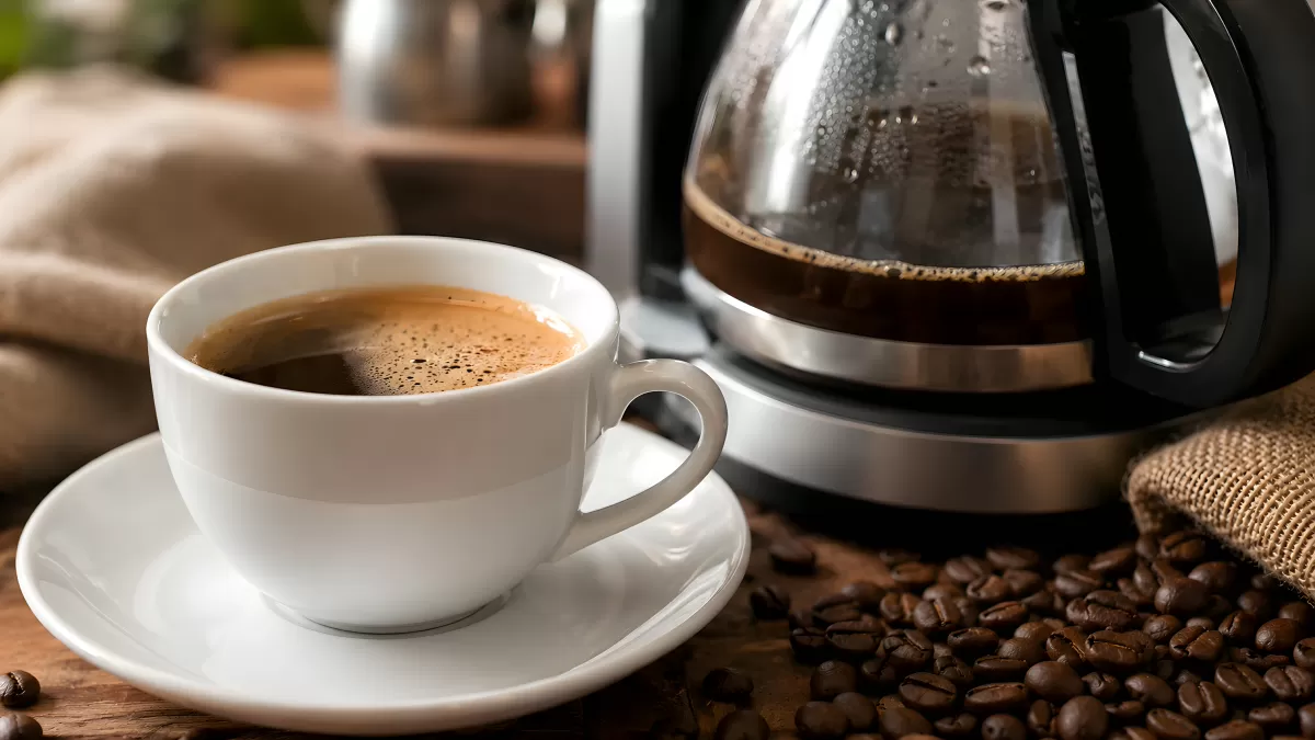 Frisch gebrühter Kaffee in weißer Tasse mit Kaffeekanne