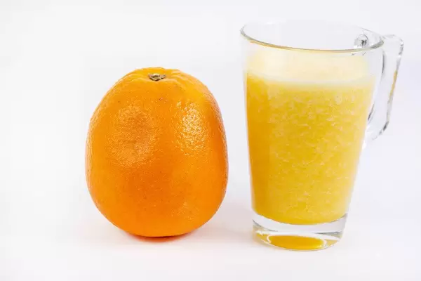 Frisch gepresster Orangensaft in Glas mit Fruchtfleisch
