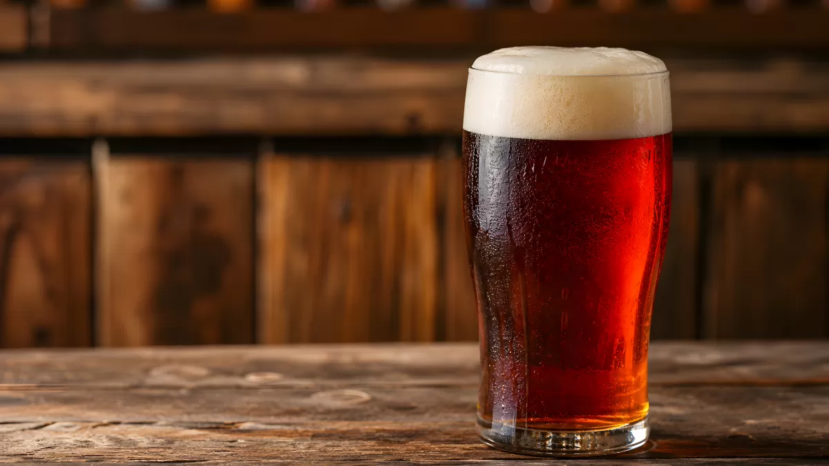 Frisch gezapftes Rotbier im Pintglas auf Holztheke