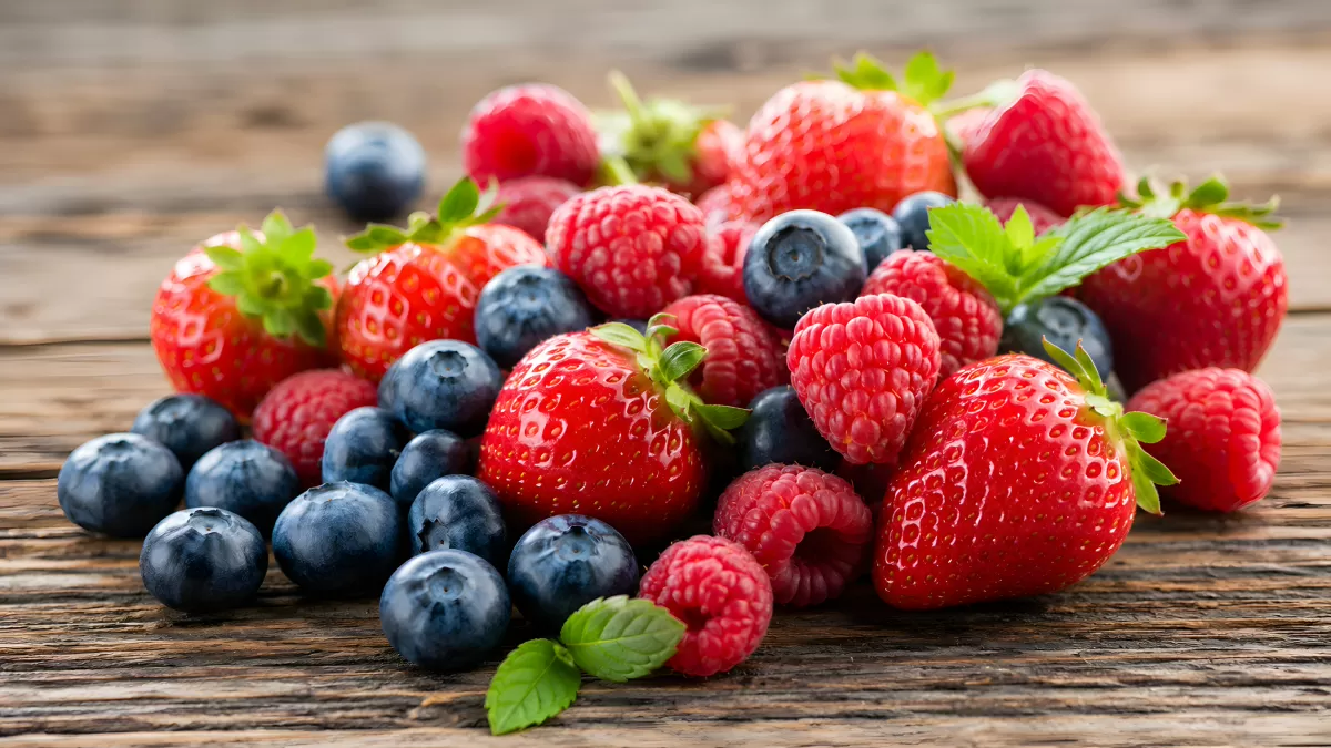 Frische Beeren auf rustikalem Holztisch arrangiert