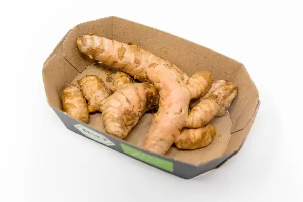 Frische Bio Kurkuma Wurzeln in einer Pappschale