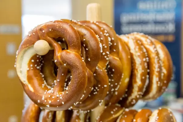 Frische Brezel mit Salz auf einem Holzständer beim Frühstück des OMWest19 Barcamps von AXA in Köln