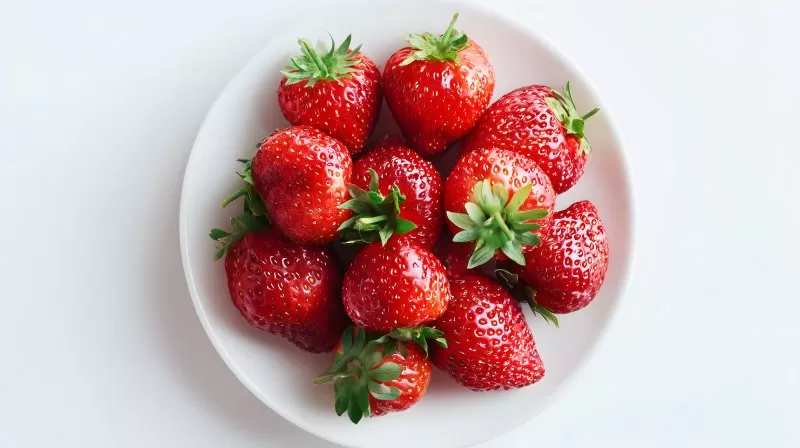 Frische Erdbeeren auf weißem Teller von oben fotografiert