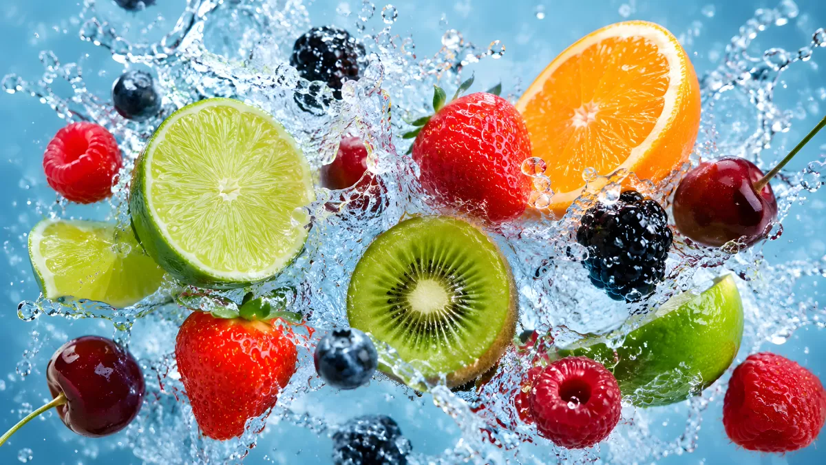 Frische Früchte spritzen durch klares Wasser