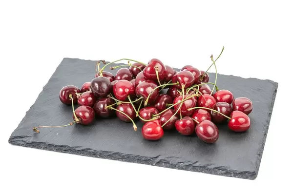 Frische, gepflückte Kirschen auf einer Schiefersteinplatte