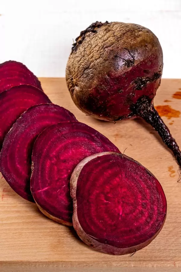 Frische rohe rote Rüben auf dem Küchenbrett