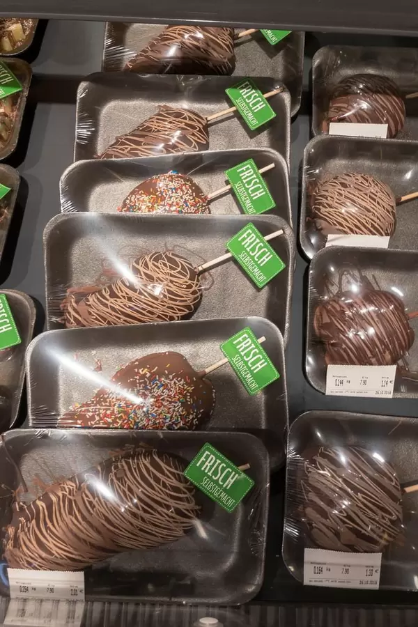 Frische selbstgemachte mit Schokolade überzogene Früchte in einem Supermarkt - Äpfel und Birnen