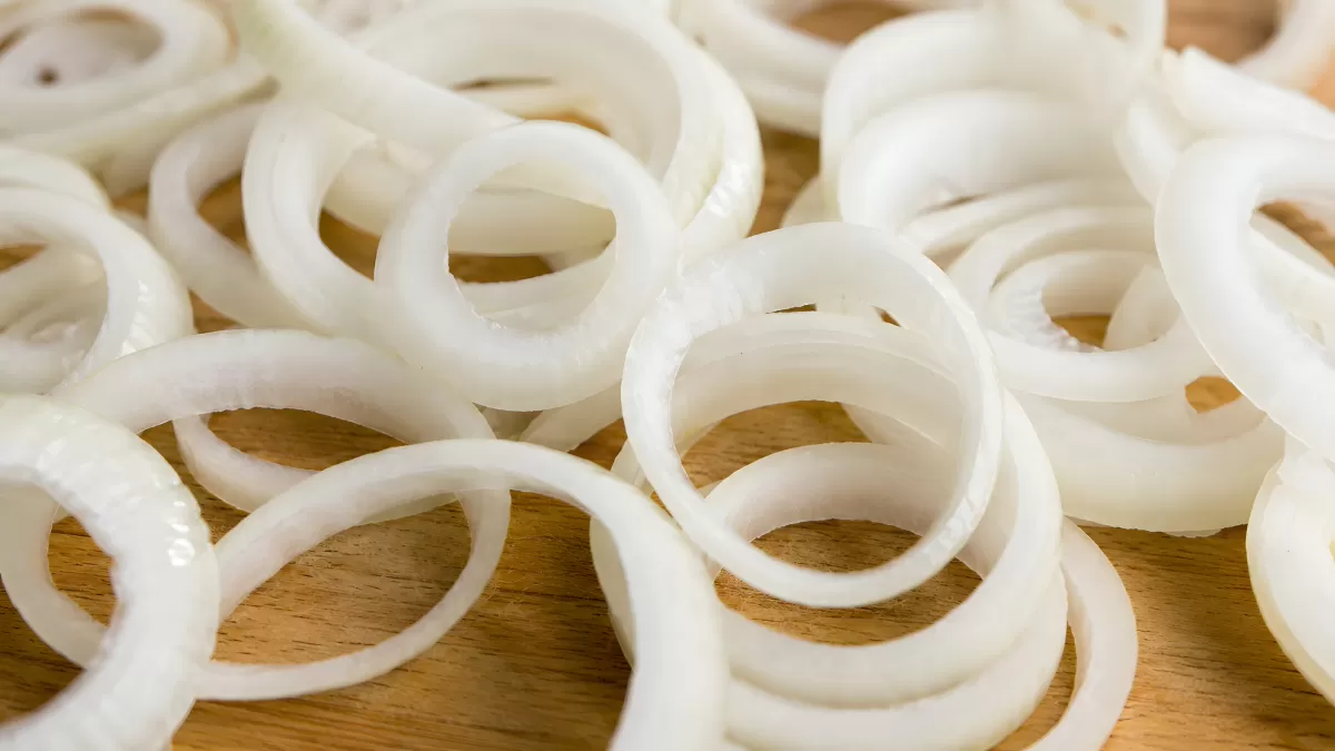 Frische Zwiebelringe auf einem Holzbrett — Bild kostenlos herunterladen