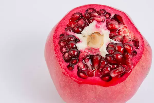 Frischer, angeschnittener Granatapfel über weißem Hintergrund