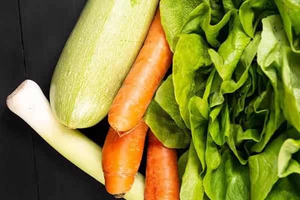 Frischer Karotten-Zucchini-Kopfsalat und Porree auf dem Tisch