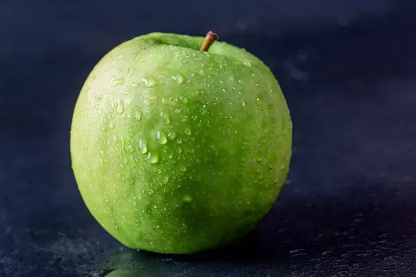 Frischer knackiger Apfel für gesunde Ernährung vor dunklem Hintergrund