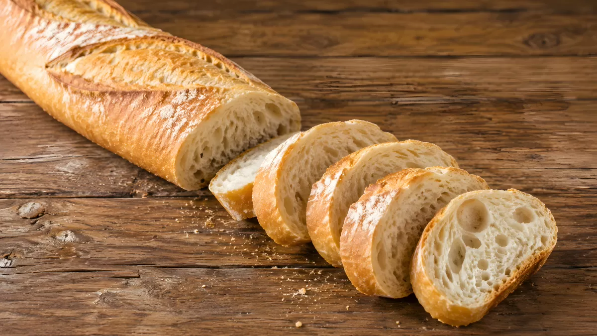 Frisches Baguette aufgeschnitten auf Holztisch