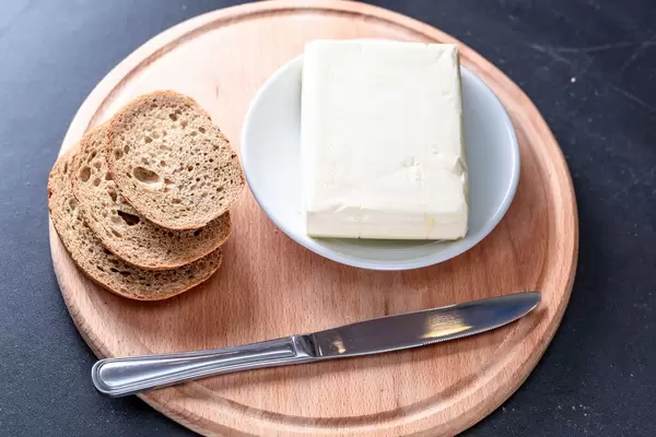 Frisches Brot mit Bitter und einem Messer auf einem Brettchen