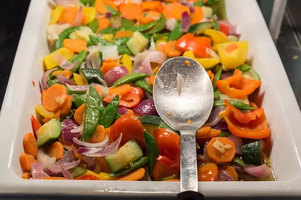 Frisches Gemüse als gesunde Beilage zum Mittagessen, in einem weißen Behälter am Essensbüfett