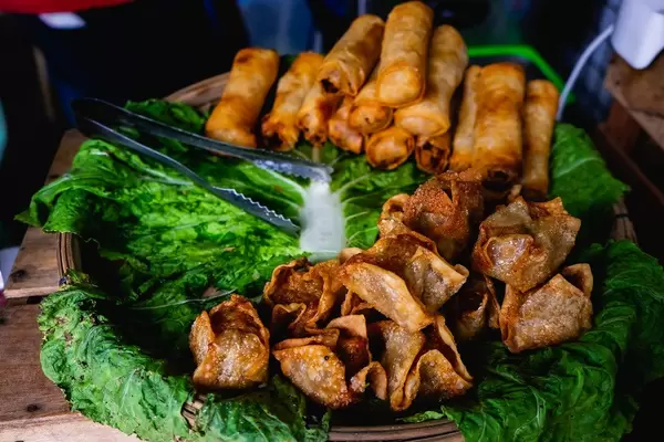 Frittierte Köstlichkeiten auf Spinatbett in einer Holzschale