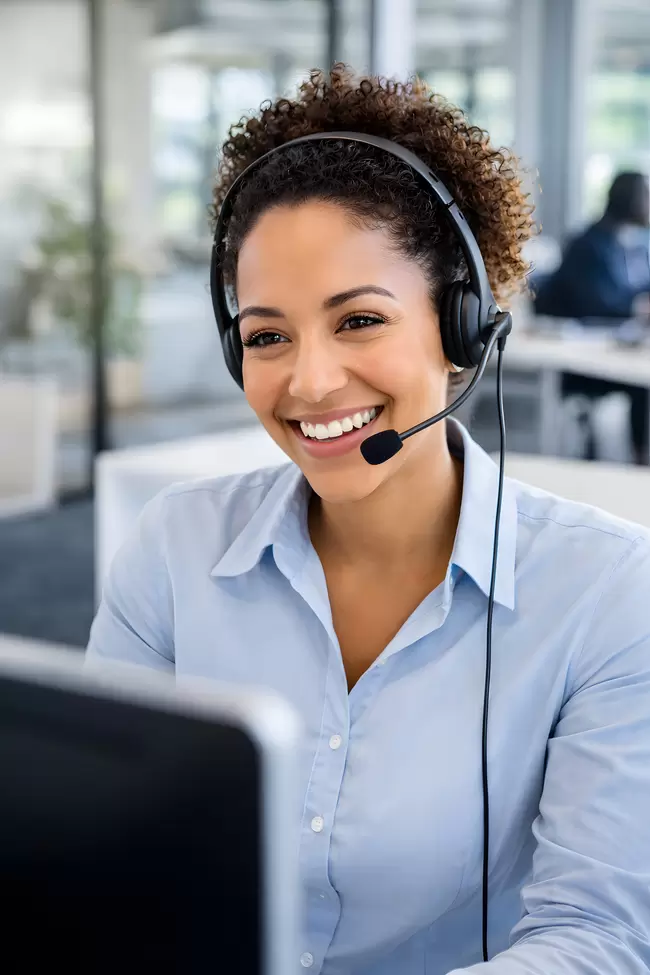 Fröhliche Call-Center-Mitarbeiterin mit Headset bei der Kundenbetreuung