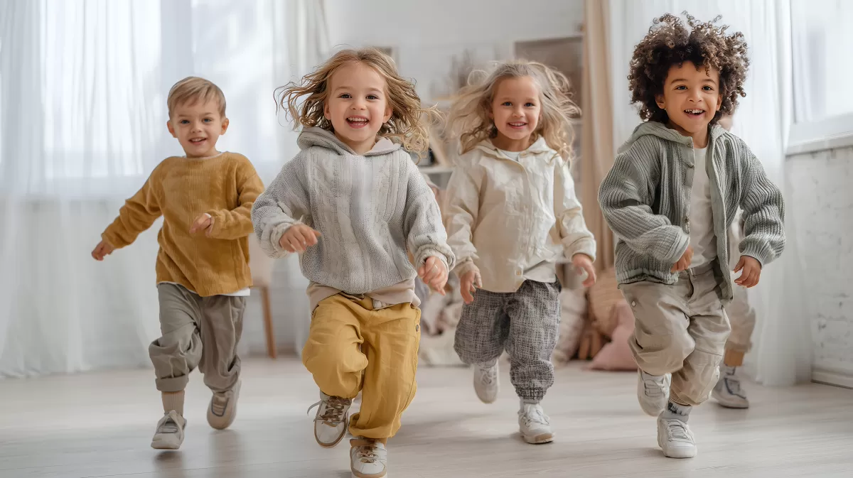 Fröhliche Kinder rennen durch helles Wohnzimmer