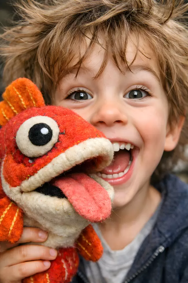 Fröhliches Kind spielt mit Kuscheltier