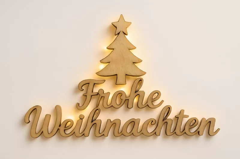 Frohe Weihnachten Holzschrift mit leuchtendem Weihnachtsbaum