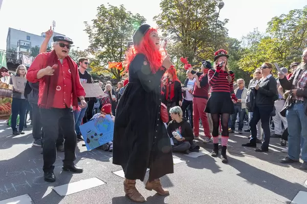 Fröhlich verkleidete Demonstranten tanzen und singen für unser Klima