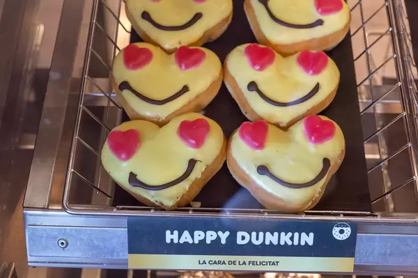 Fröhliches Gebäck in Herzform mit Smiley-Gesicht "Happy Dunkin" von Dunkin Donuts in Barcelona, Spanien