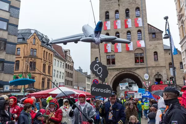Frohsinn for Future thematisiert umweltschädliche CO2-Abgase beim Kölner Rosenmontagsfest, mit Severinstor im Hintergrund