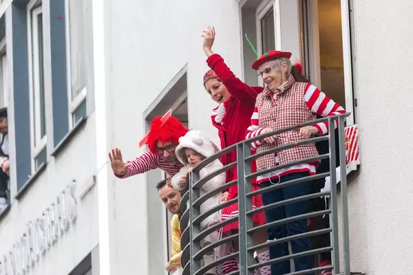 From the balconies of Cologne, people in traditional red and white costumes (red-white are the colours of the city) cheer and greet as the Rose Monday parade passes by