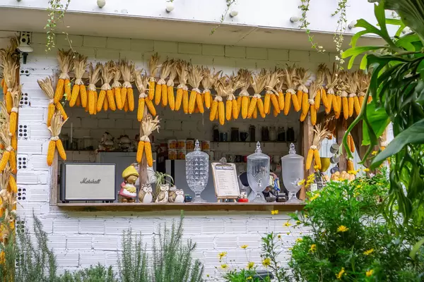 Front of a Cafe Bar with Corn on the Cob Decorations and many Flowers