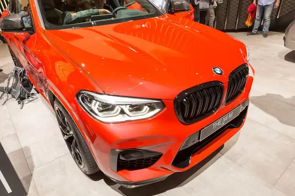 Frontansicht des Sportwagens BMW x4 M Competition in rot, mit Sportauspuff und Reihensechszylinder-Motor