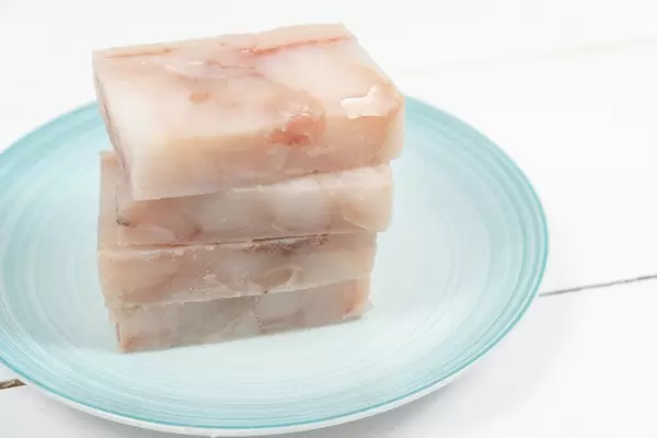 Frozen Alaska Pollock fish on the plate ready for frying (Flip 2020)