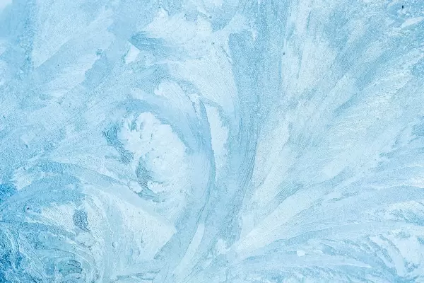 Frozen glass with beautiful ice patterns in light blue