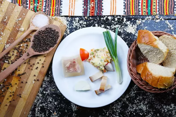 Frühstück-Idee aus der Balkanküche mit Speck, Schweinefleisch in Aspik, Lauch und Rindfleischsalat serviert mit Brot