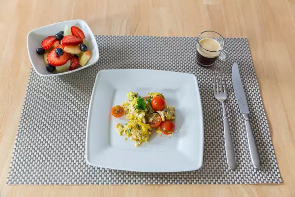 Frühstück: Rührei, Obstsalat und Espresso
