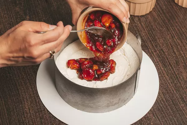 Fruit filling for the homemade cake pours out of the bowl