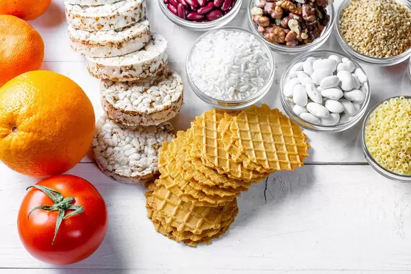 Fruits, cereals, loaves, walnuts on white wooden background