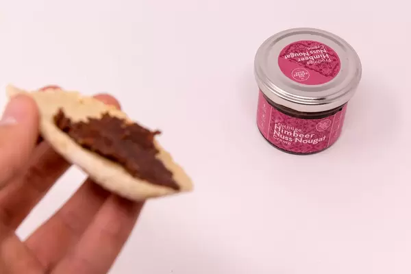 Fruity Raspberry Nut Nougat Spread in jar with bread in front