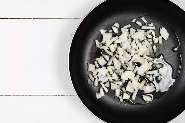 Frying Onions in the hot oil with copy space above white boards