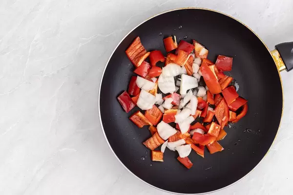 Frying Paprika and Onions in the frying pan with copy space