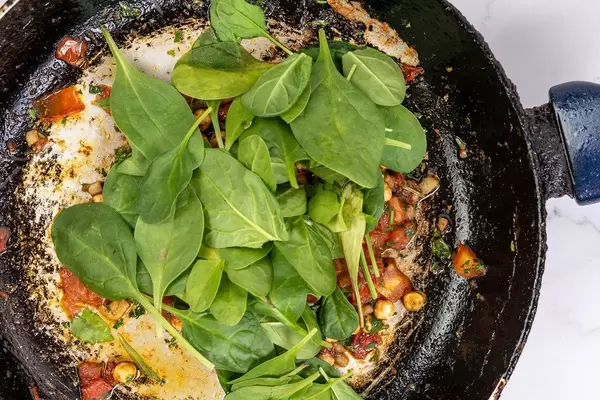 Frying sliced Tomato with Chickpeas and Baby Spinach
