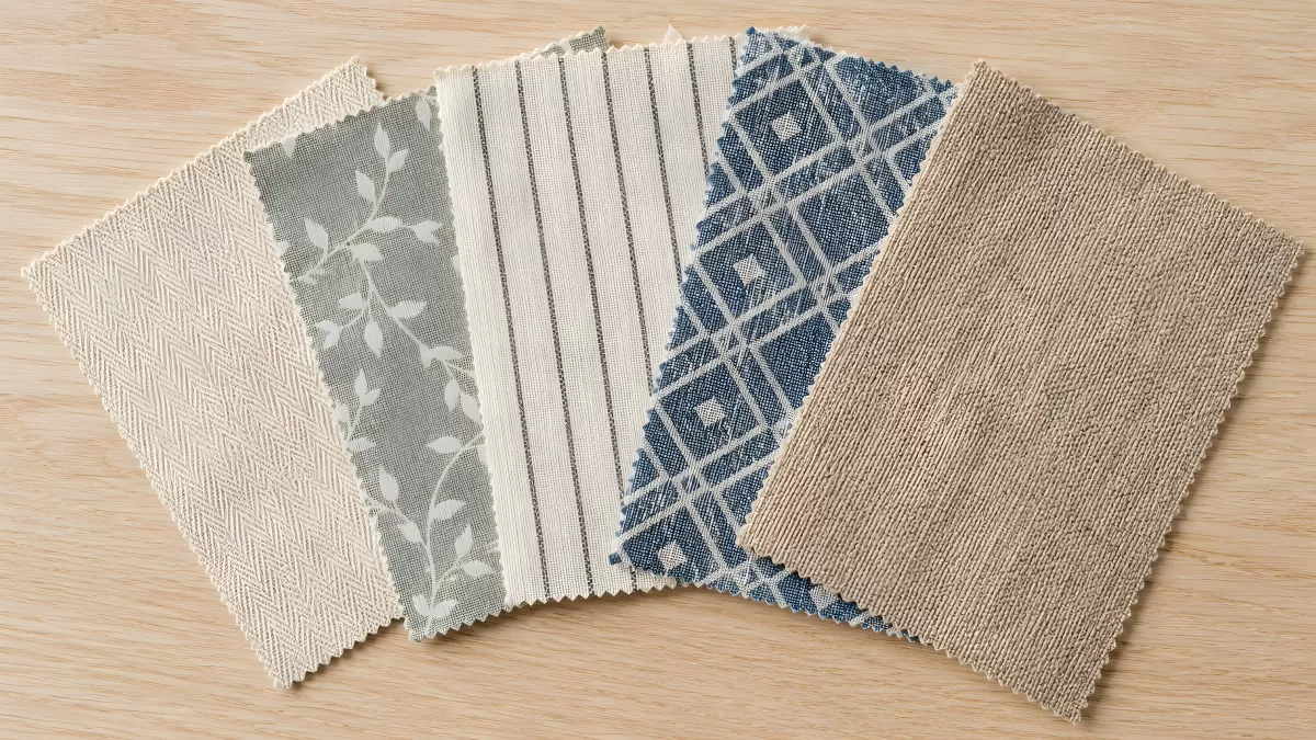 Fünf Stoffmuster in Blau und Beige auf Holzuntergrund